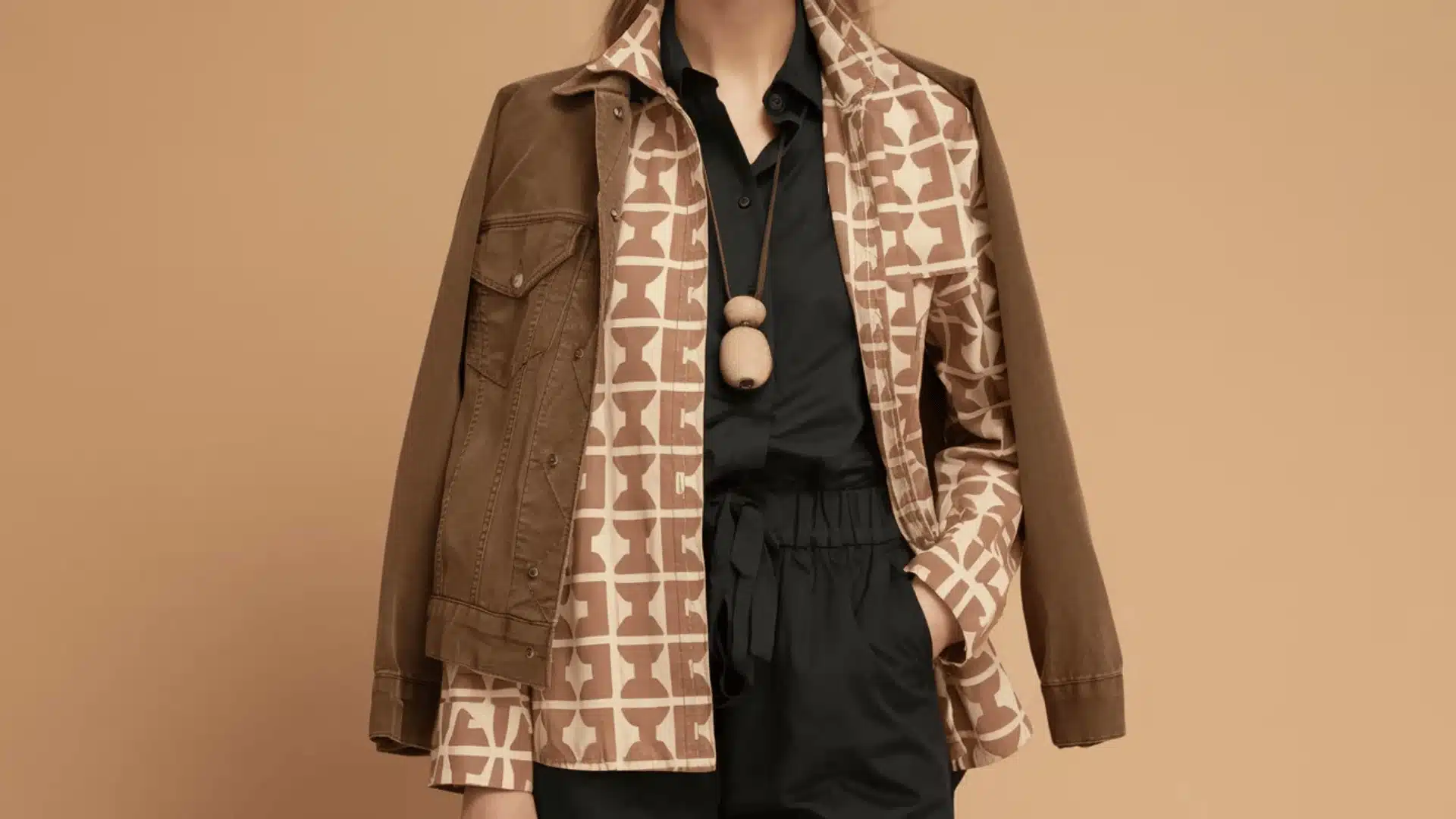 A woman in a brown jacket and trousers stands with fashion choice