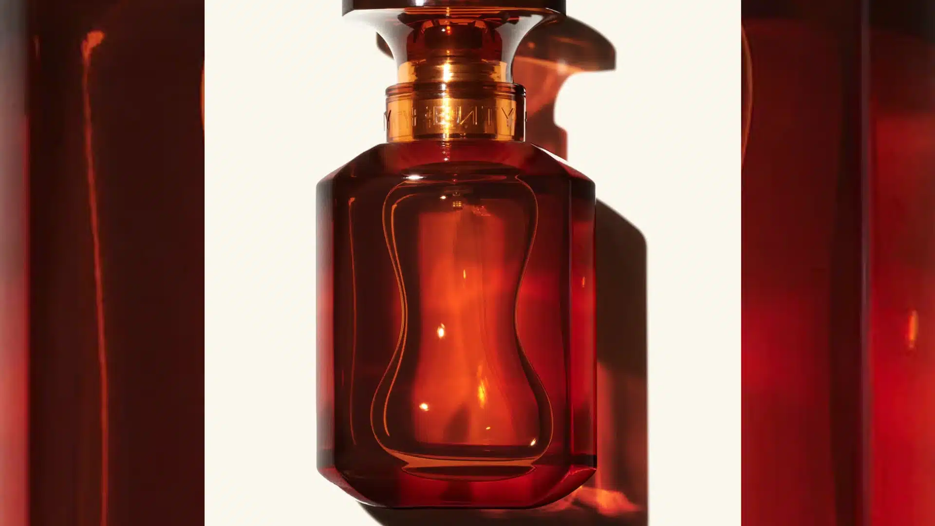A bottle of perfume elegantly placed on a smooth white surface, showcasing its design and color.