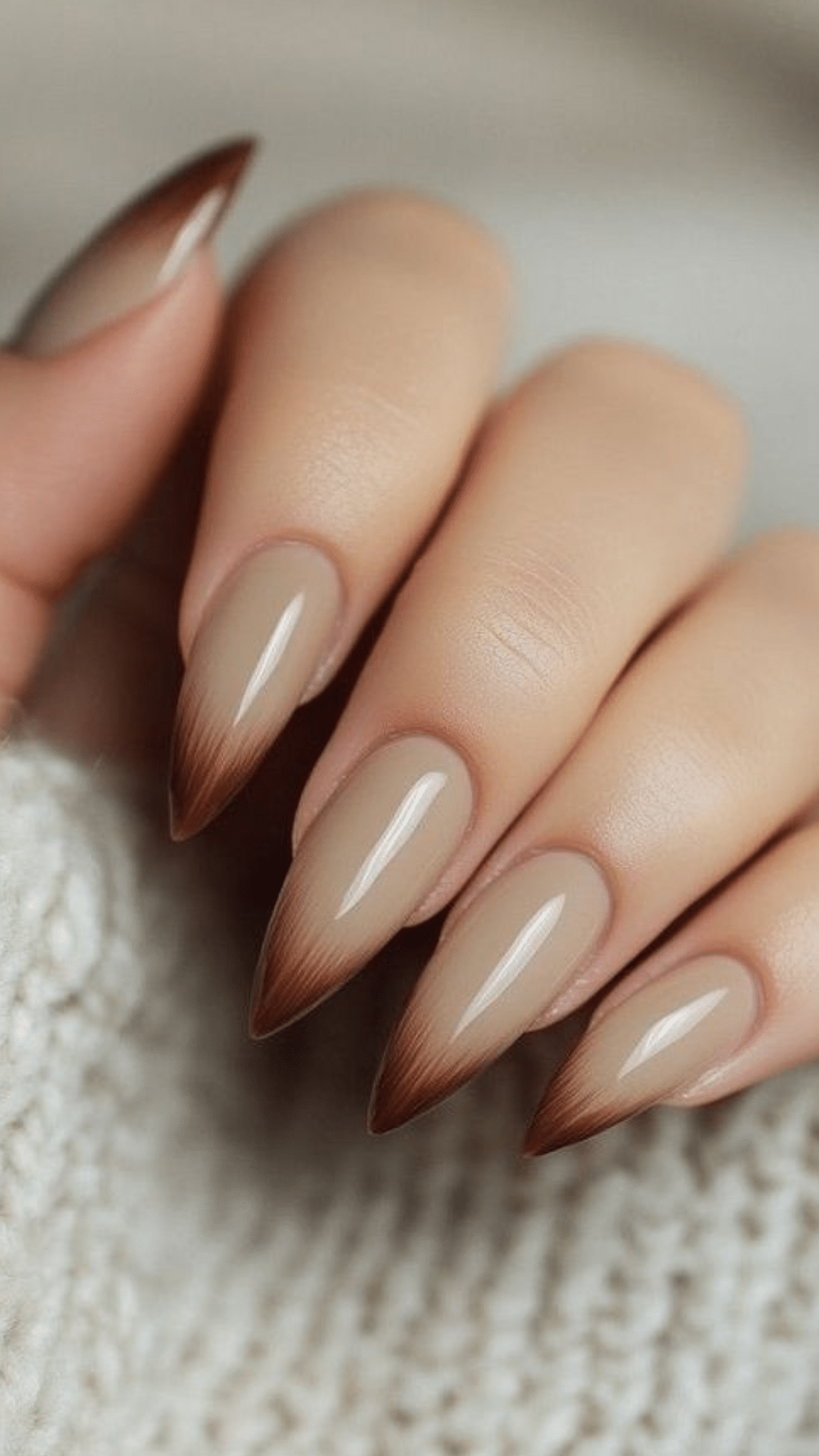 Almond-shaped nails with a nude base fading into soft brown tips