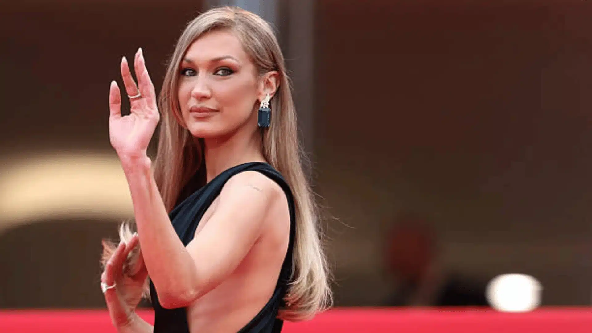 Bella Hadid waves at the red carpet during a film festival showcasing her glamoros style