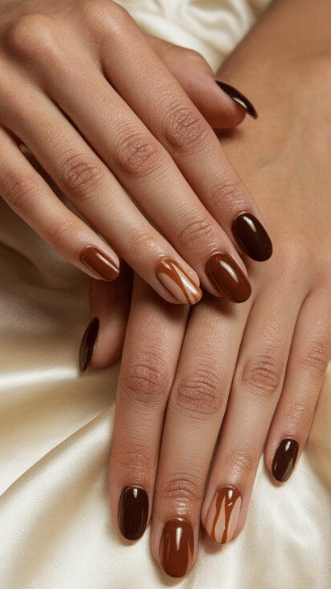 Almond-shaped nails in varying shades of brown with abstract caramel drip accents on a few nails