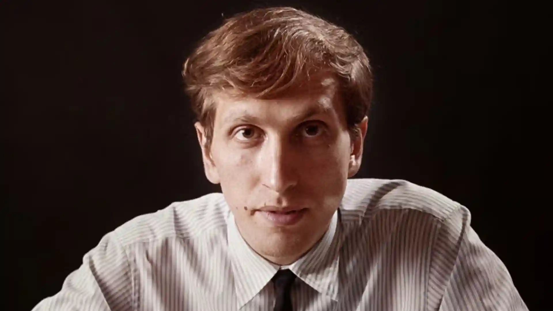 Portrait of Bobby Fischer, chess grandmaster, in striped shirt and tie.