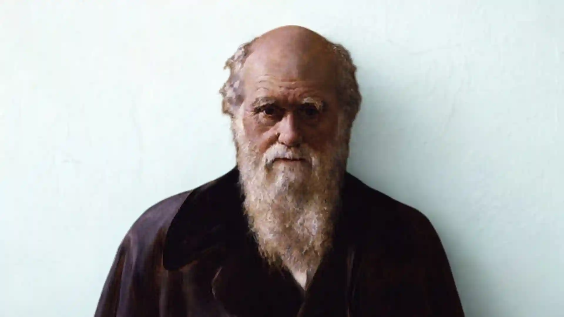 A colorized portrait of Charles Darwin with a bald head and a long white beard.