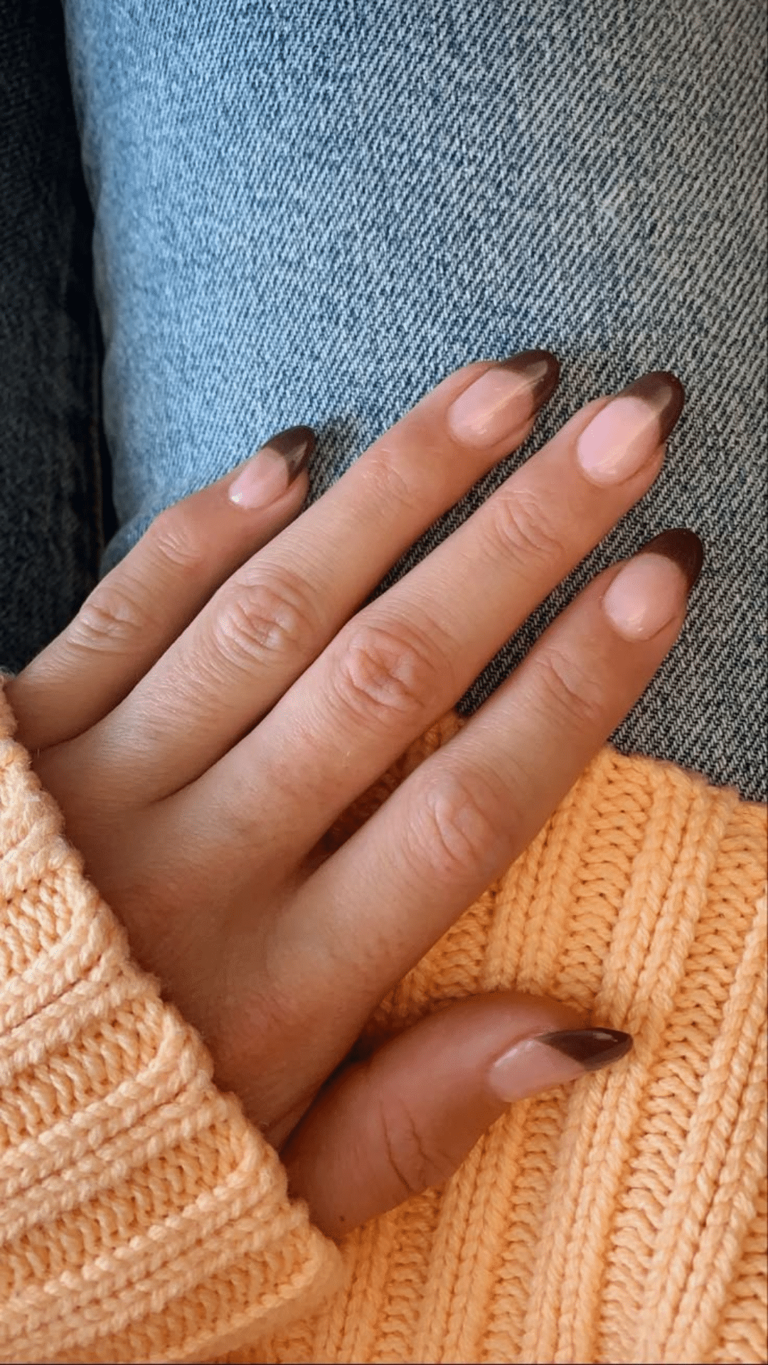 Chic almond-shaped nails with a soft nude base and dark brown tips, ideal for a classy brown nail designs look.