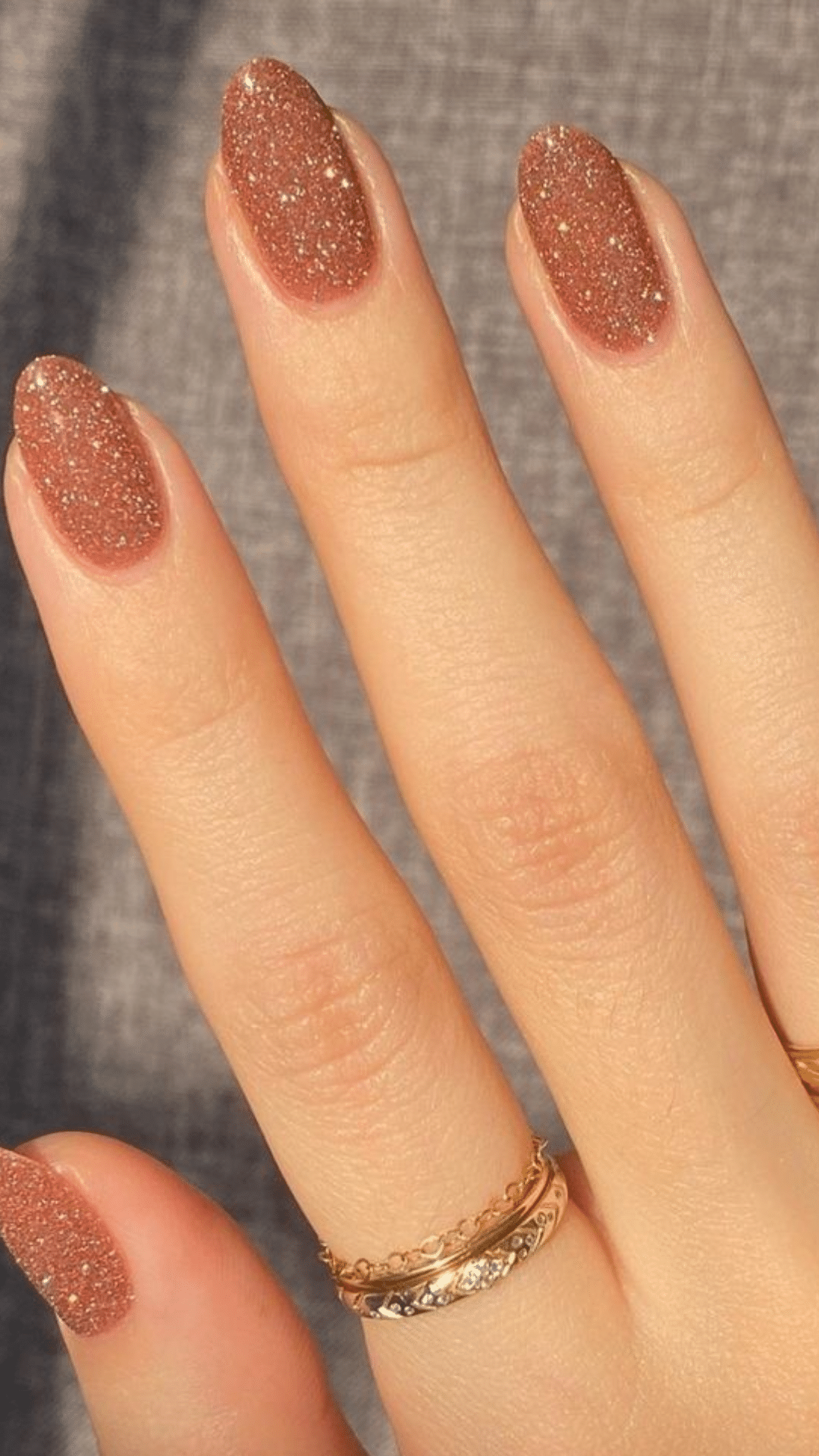 Nails with a sparkling copper brown glitter finish, creating a festive look.