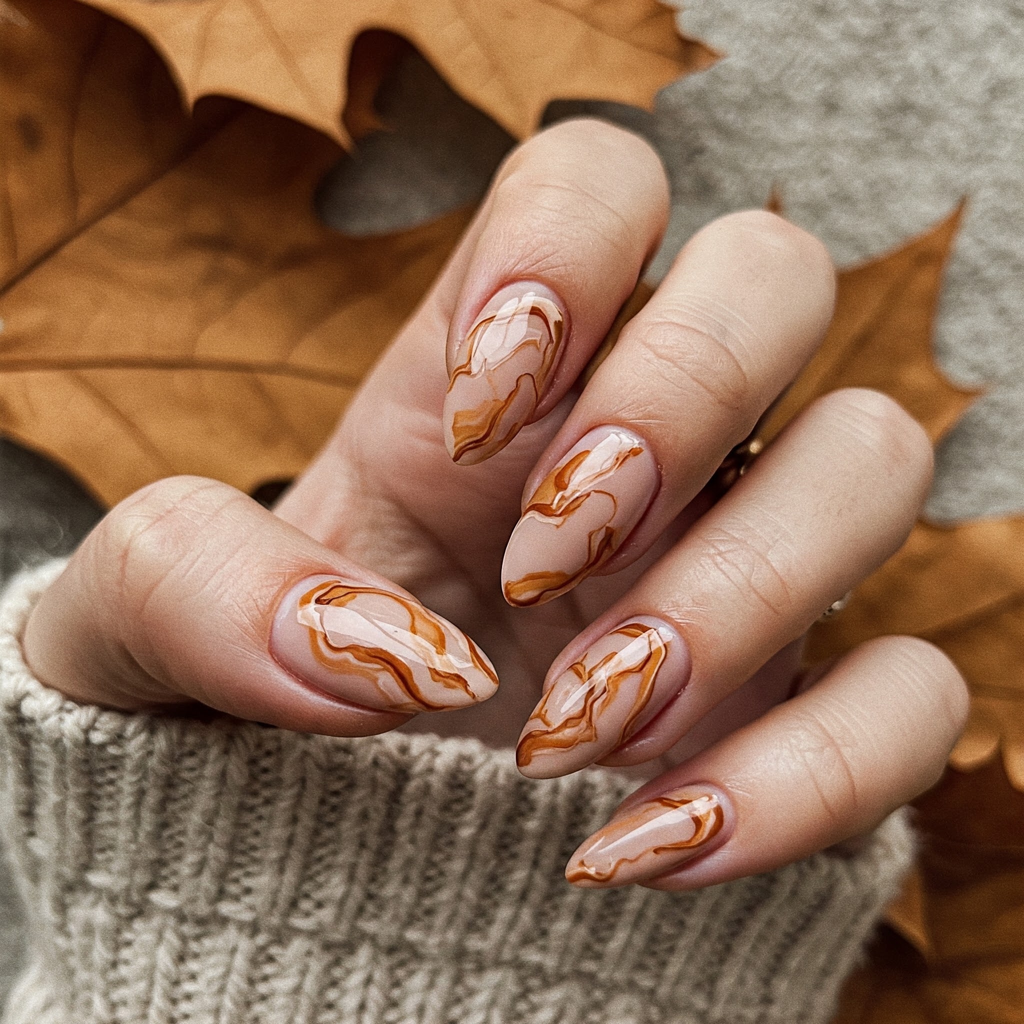 Nails with swirl design with beige and brown nail design.