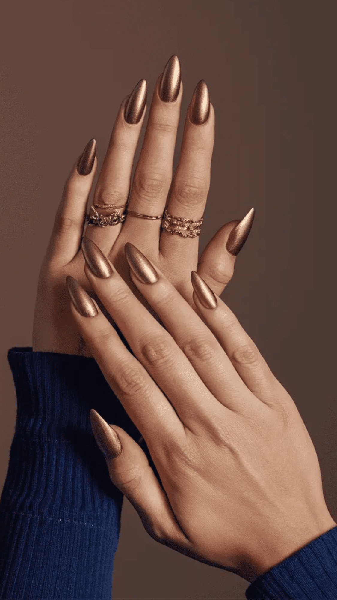 Almond-shaped nails with a metallic bronze finish, creating a sleek, and bold look.