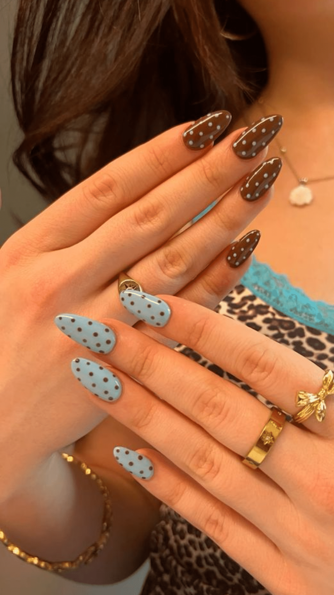 Almond-shaped nails featuring brown and pastel blue polka dots, offering a playful classy brown nail designs style.