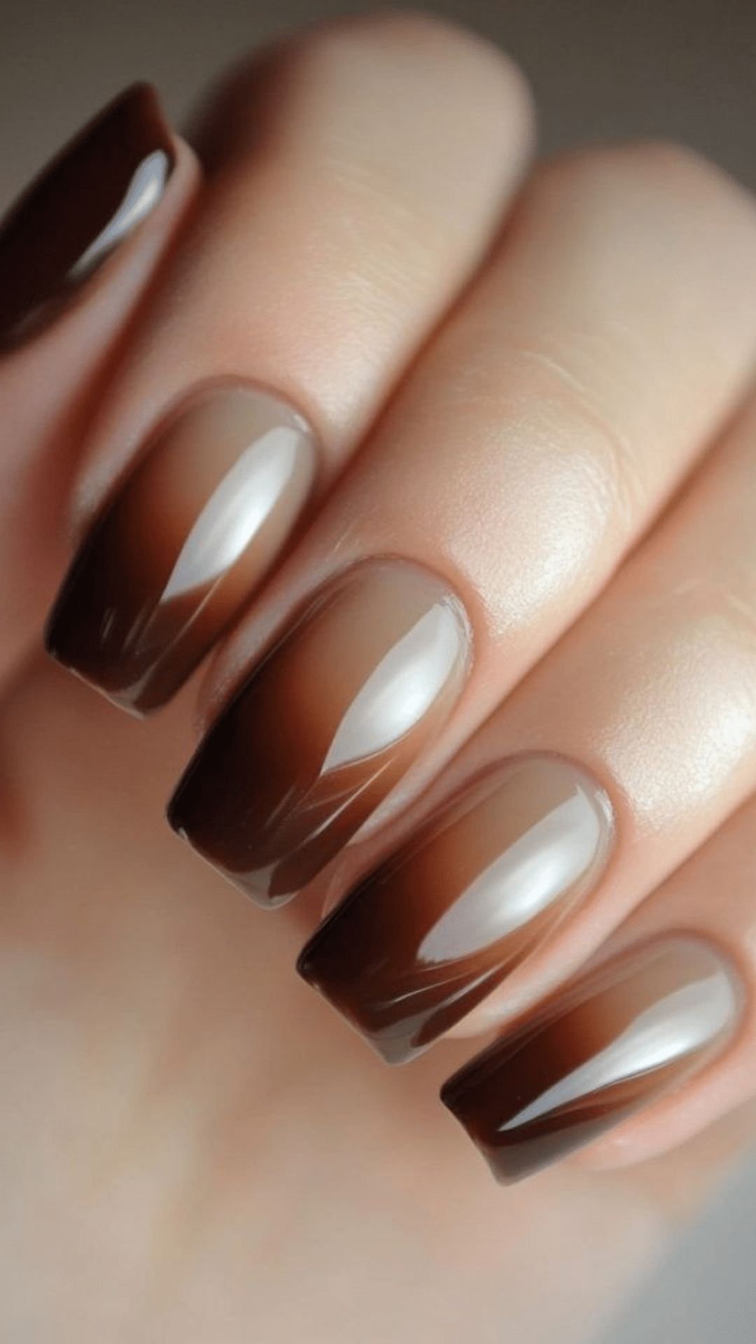 Nails with a smooth brown ombré effect, transitioning from light to dark, creating a sleek classy brown nail designs look.