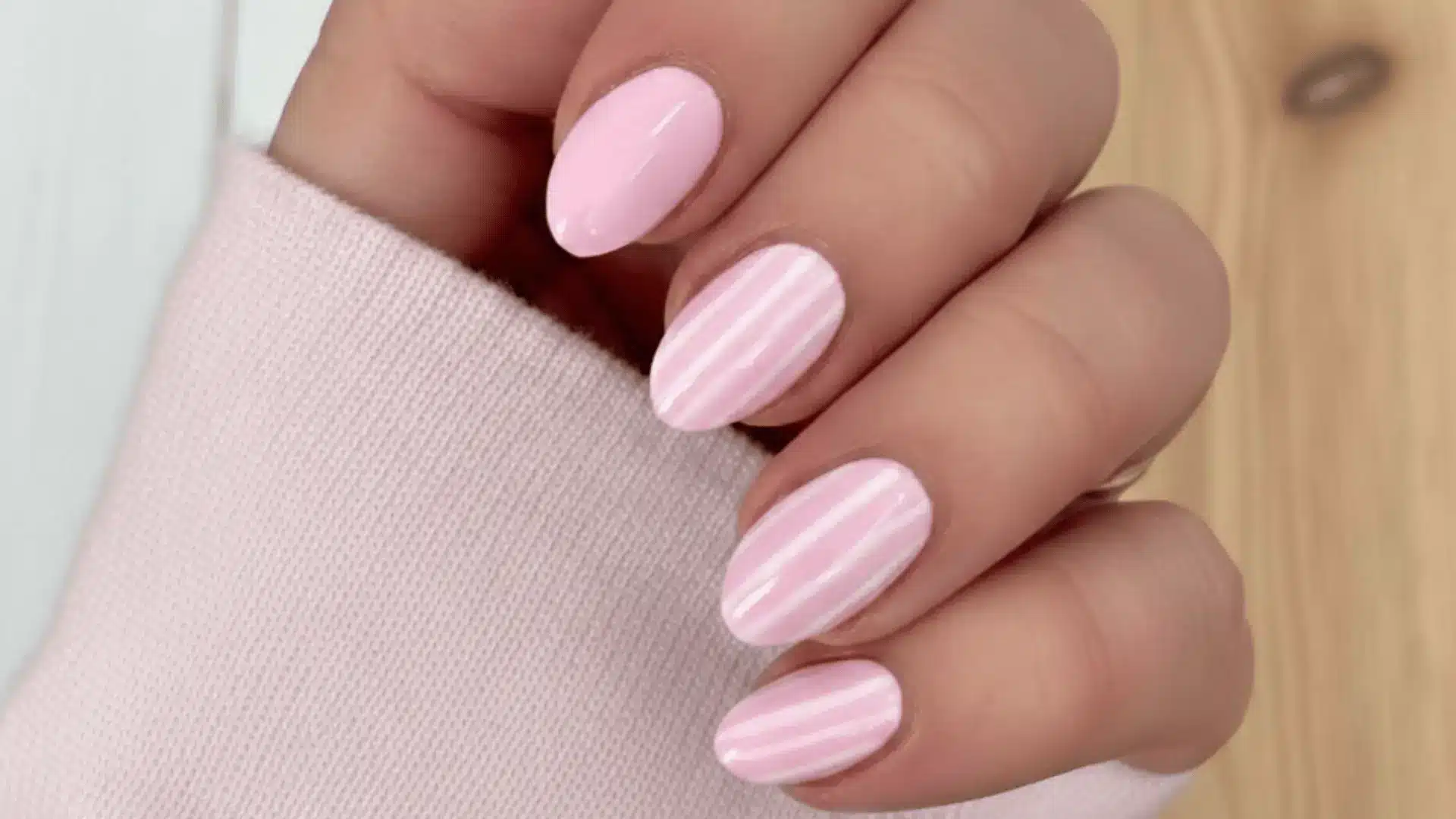 Featuring pink white nails with soft white stripes creating a bold and trendy design with clean, contrasting lines for a chic look