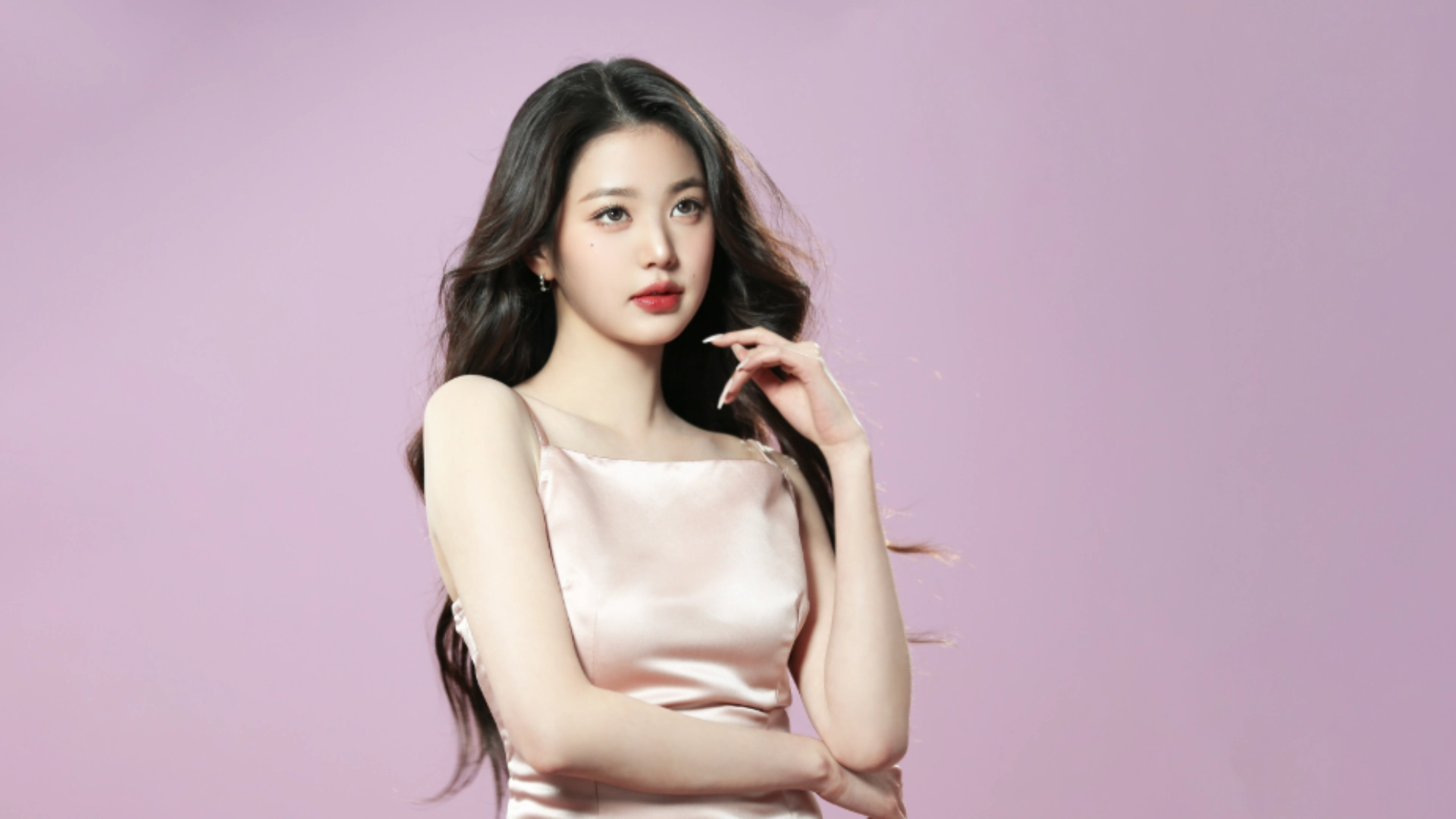 Jang Wanyoung in a pink dress smiles and poses for the camera, showcasing her stylish outfit.