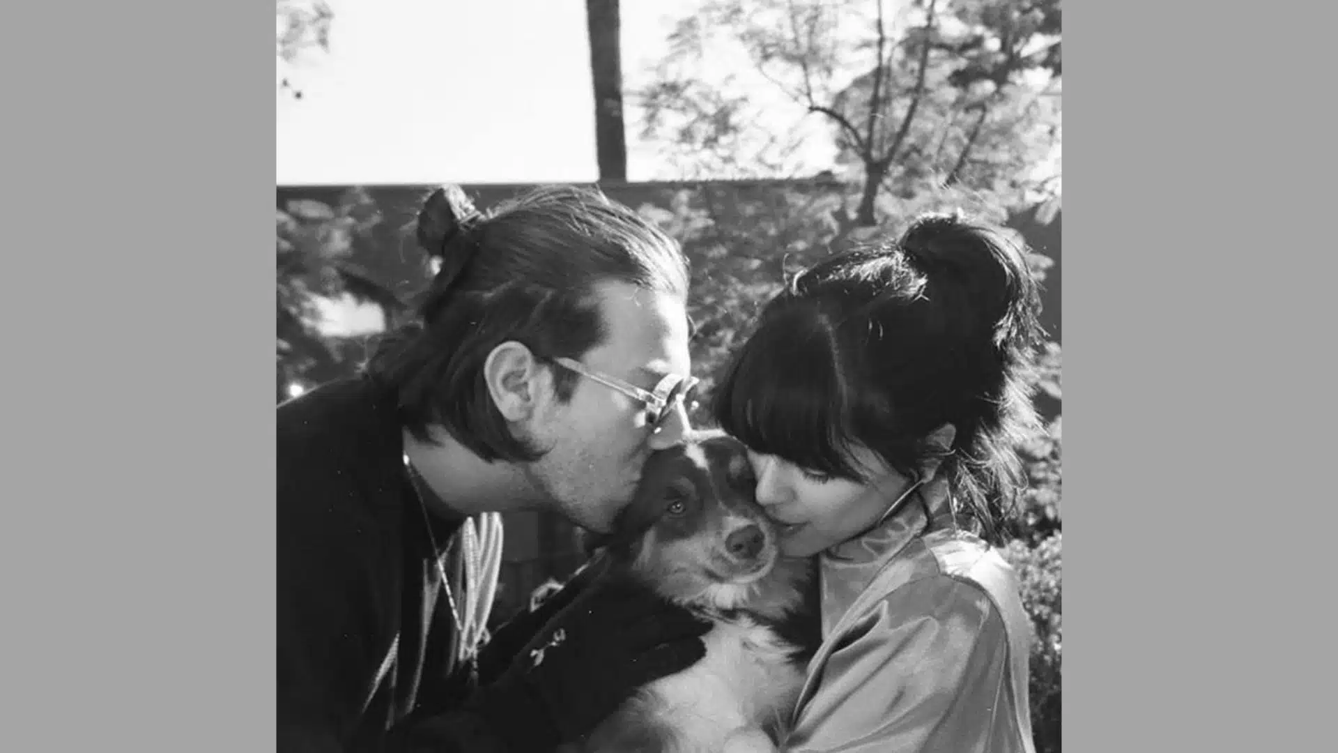 Josh Conway kisses a dog on the forehead while Maria holds it close