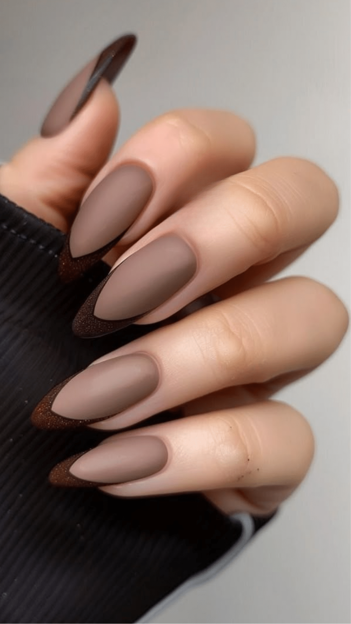 Matte almond-shaped nails in soft brown with dark chocolate pointed tips, a stylish and classy brown nail designs choice.