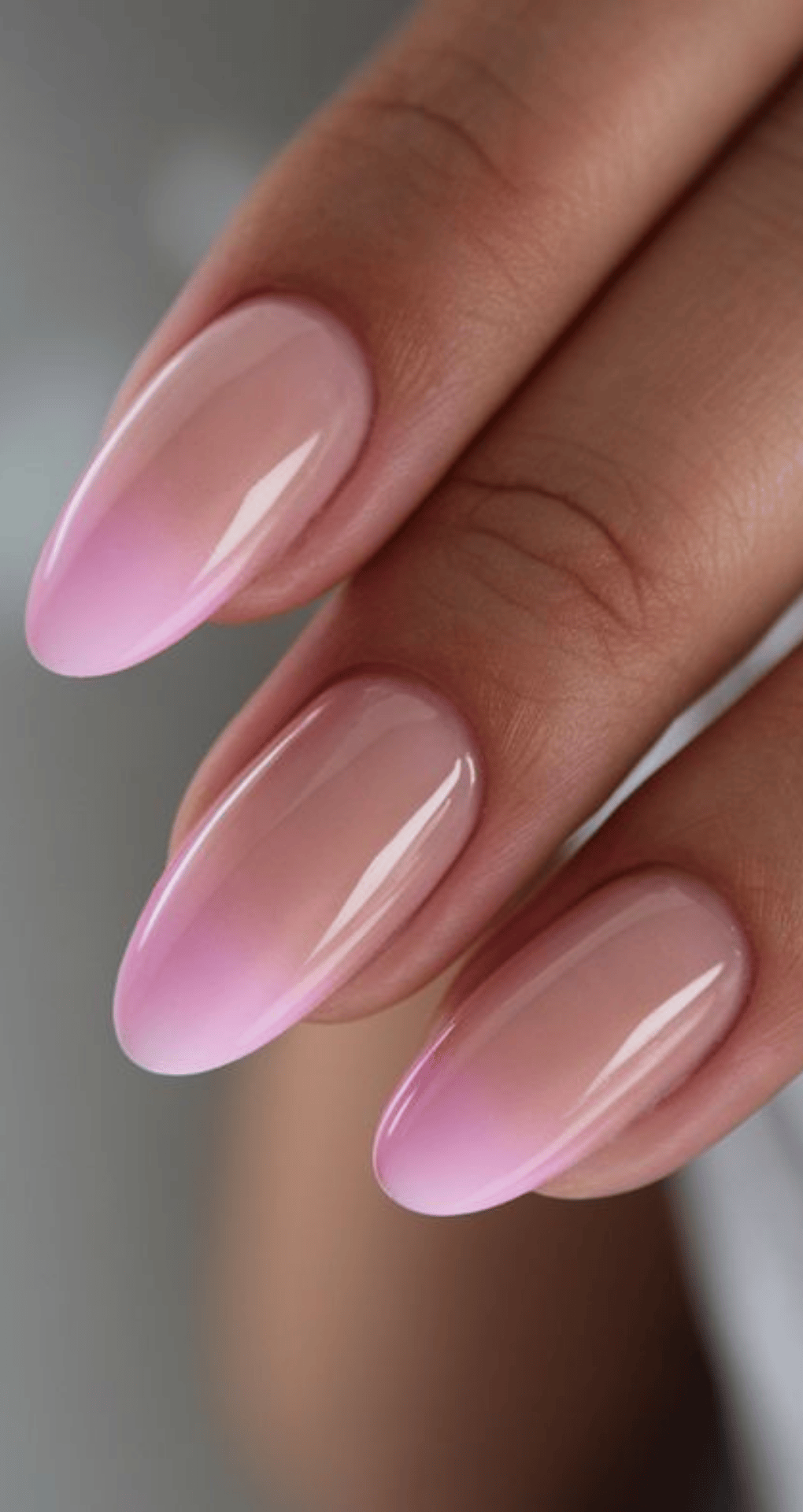 Long oval nails with smooth pink ombre transitioning from nude to soft pastel pink tips