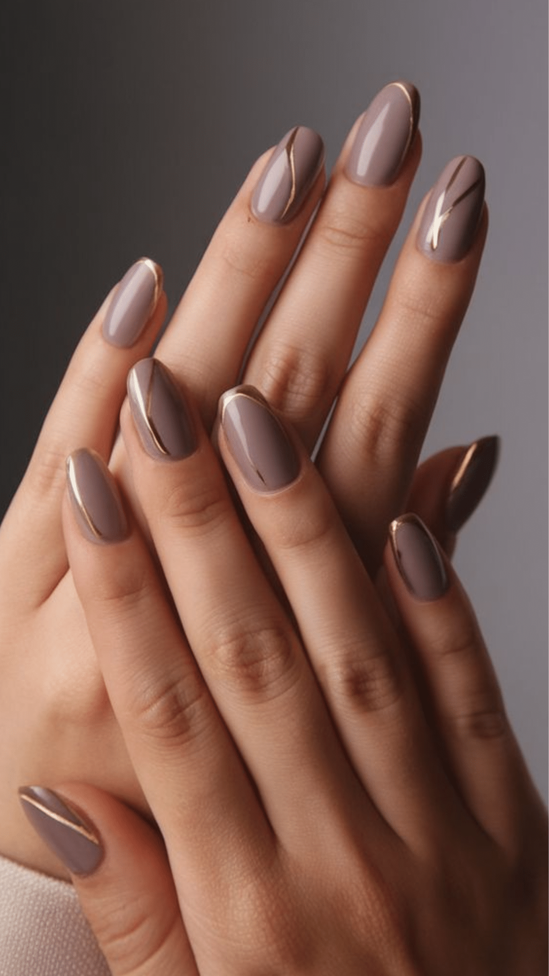 Matte taupe nails with gold line accents and tips, creating a classy brown nail designs look.
