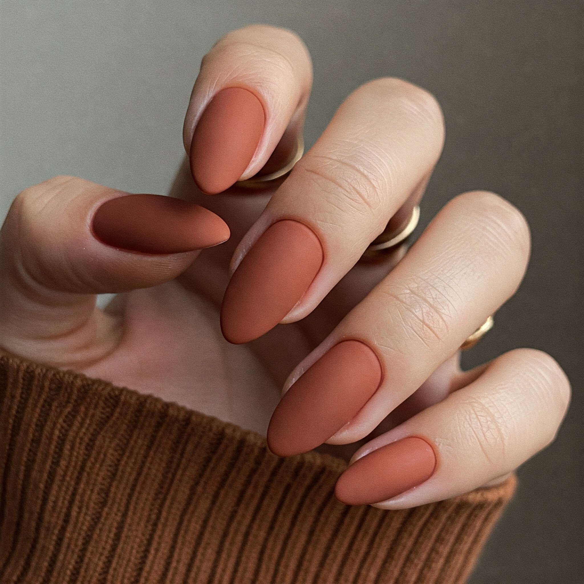 A woman's hand displaying neatly manicured nails in a rich brown color.