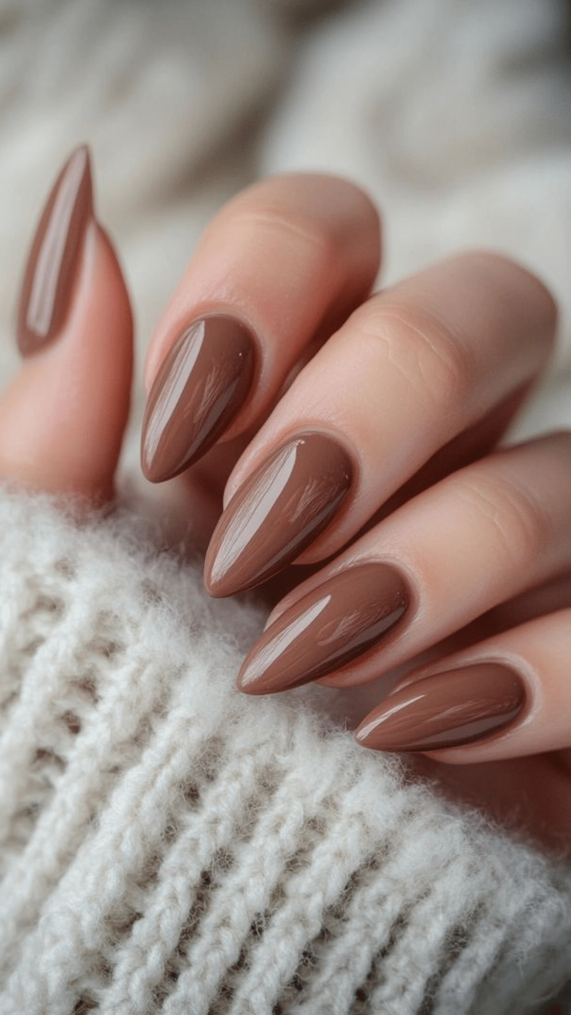 Glossy almond-shaped nails in rich chocolate brown, creating a simple classy brown nail designs look.