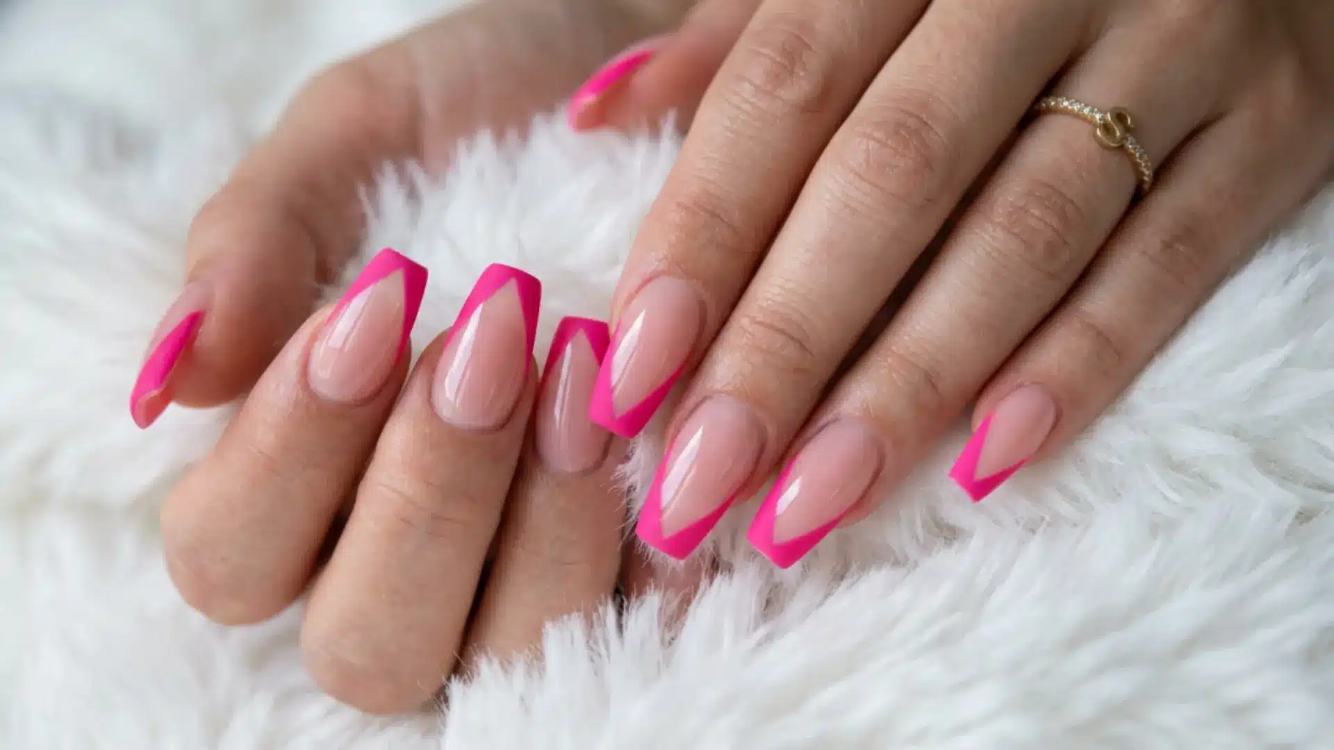 hot pink V cut French tip on long coffin nails with a sharp angled tip over a clear nude base