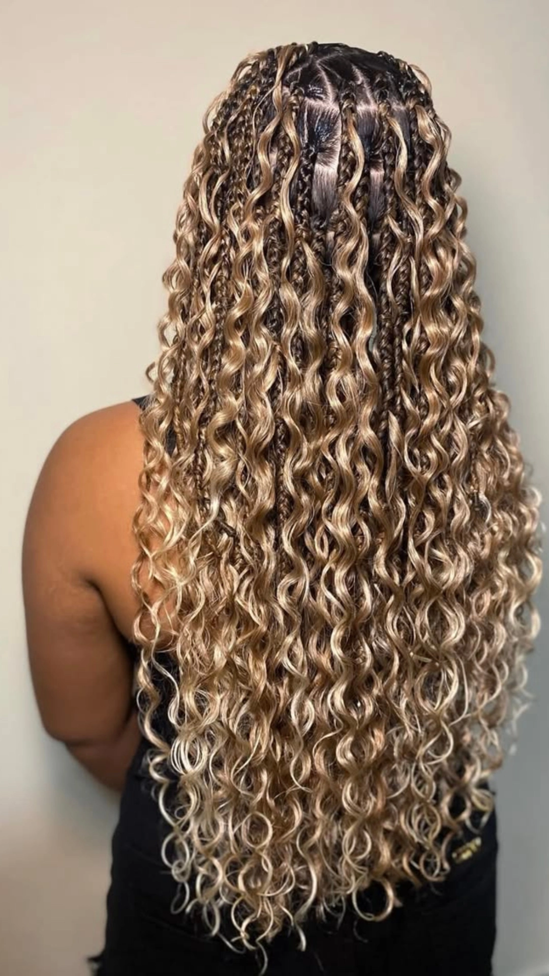 Goddess braids with curly blonde highlighted ends worn down the back