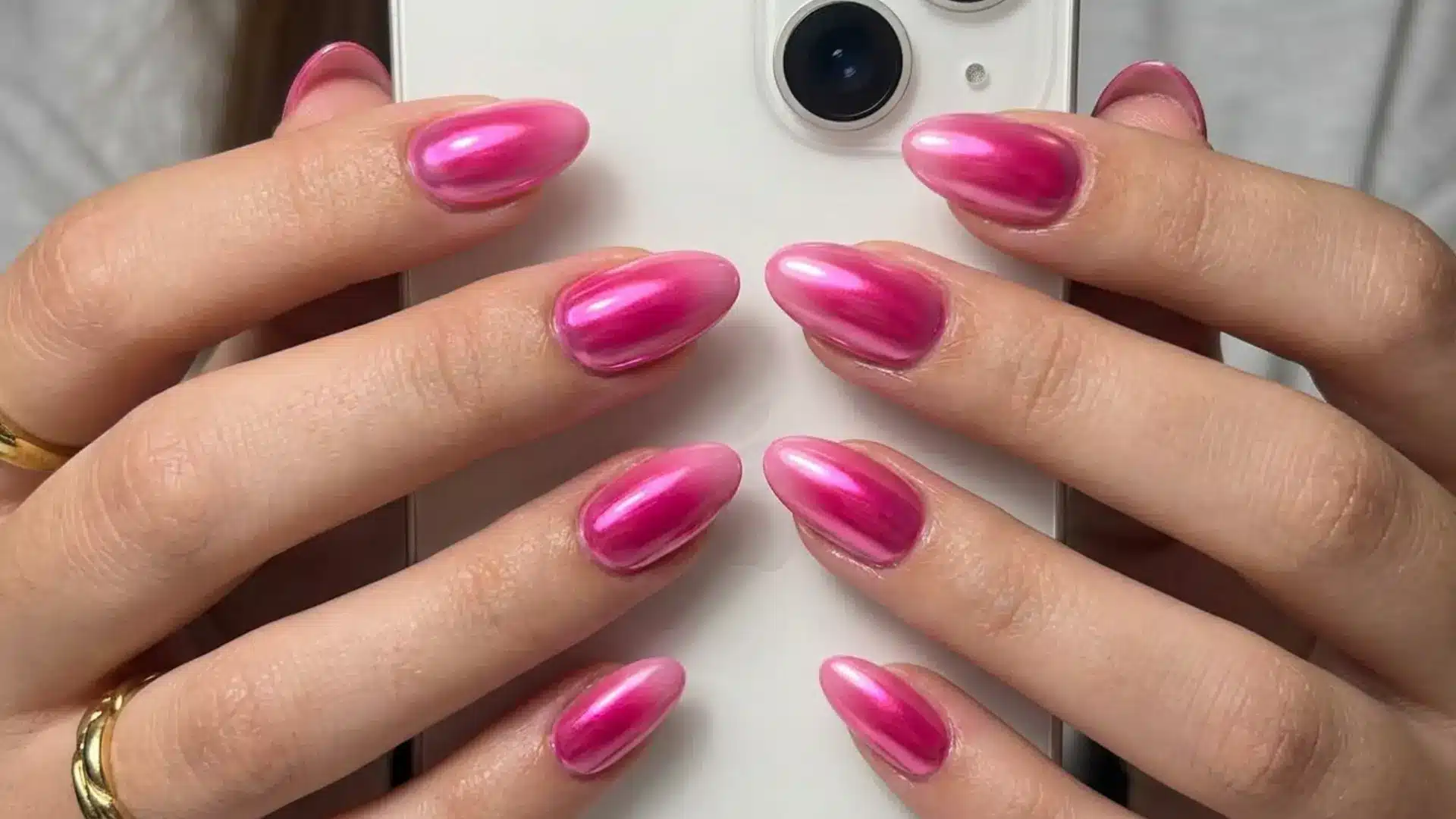 hot pink chrome aura almond nails with a soft glowing metallic center and pink pearl effect finish