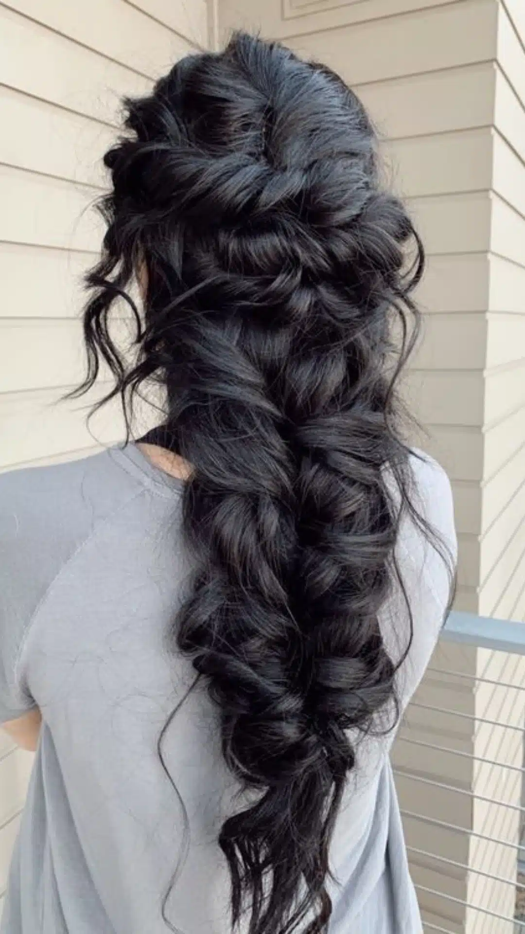 Thick interwoven braid cascading down the back with soft curls