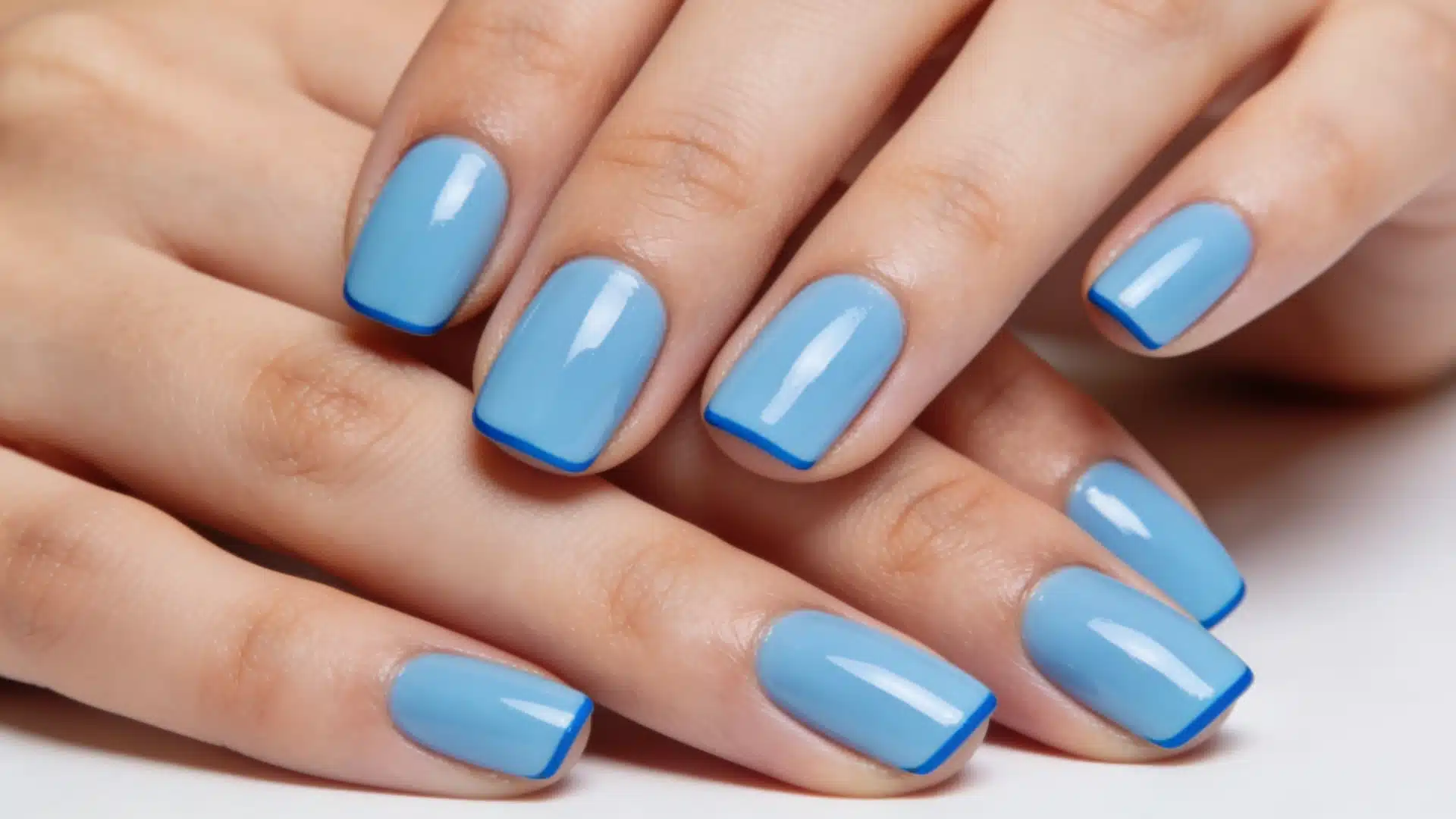 Bright pastel blue French manicure featuring bold baby blue and cornflower blue tips for a trendy, modern look.