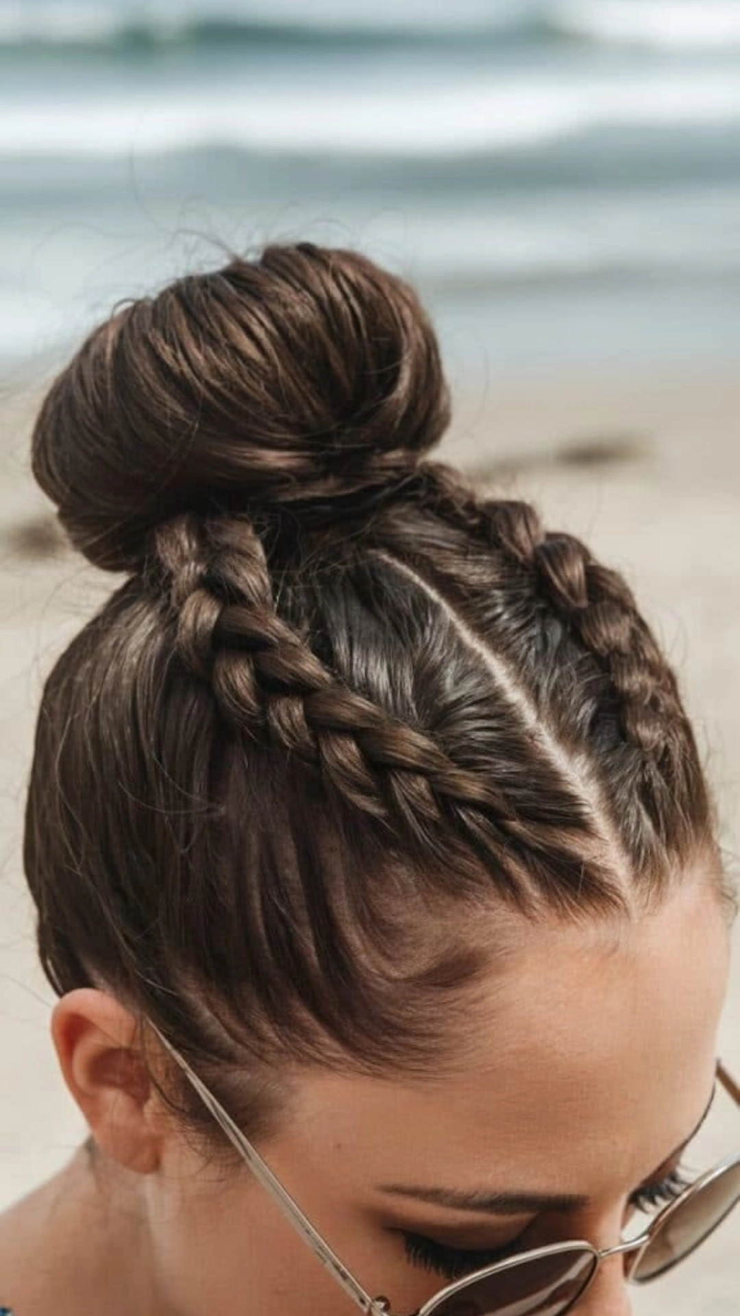 Double braids leading into a high bun, styled at the beach