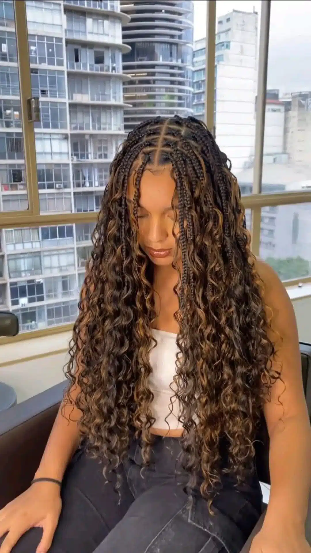 black girl with long classic boho knotless braids and defined loose curls with center part and natural finish