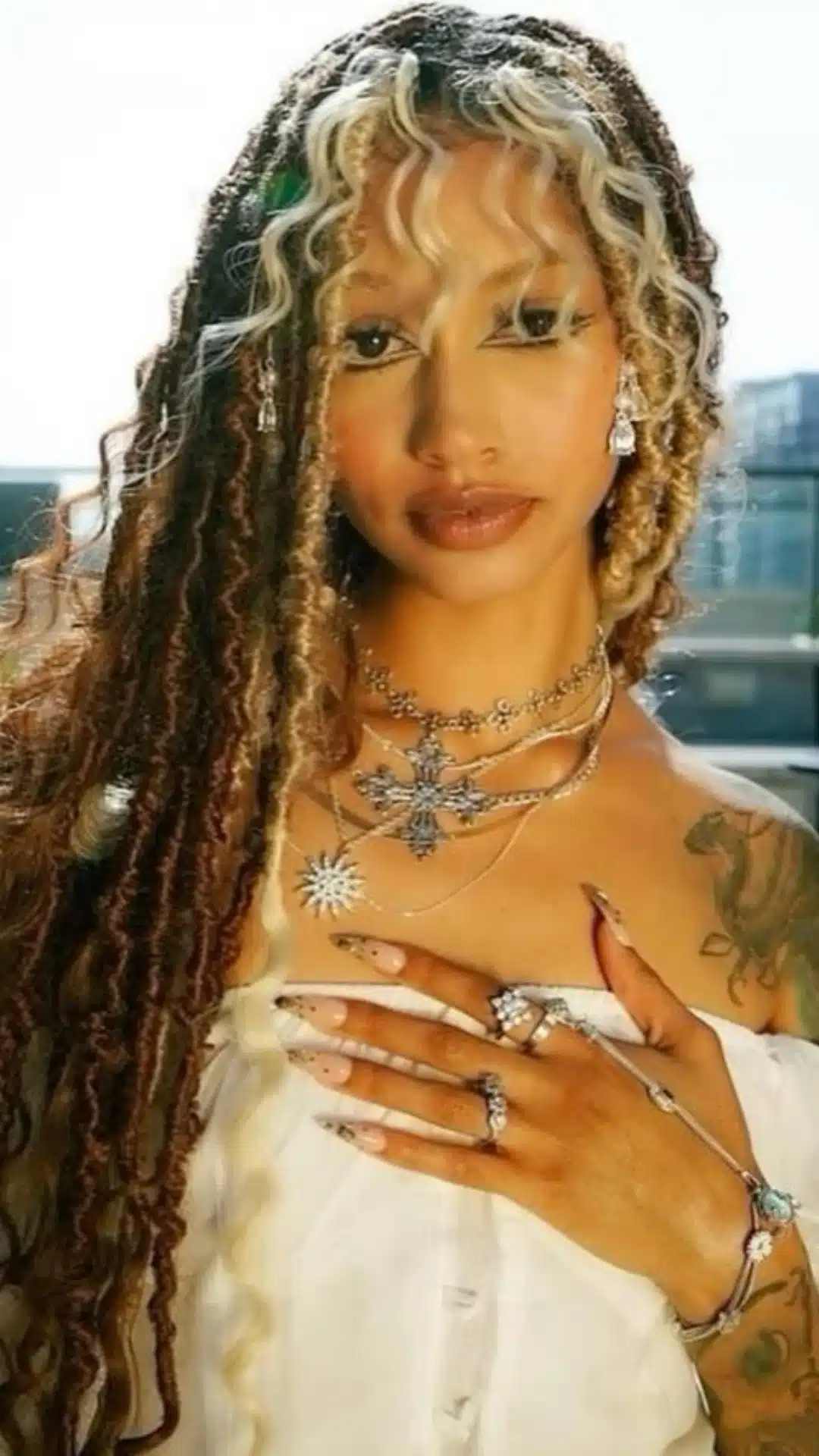 black girl with boho braids and curly bangs featuring blonde face framing strands and long protective hairstyle