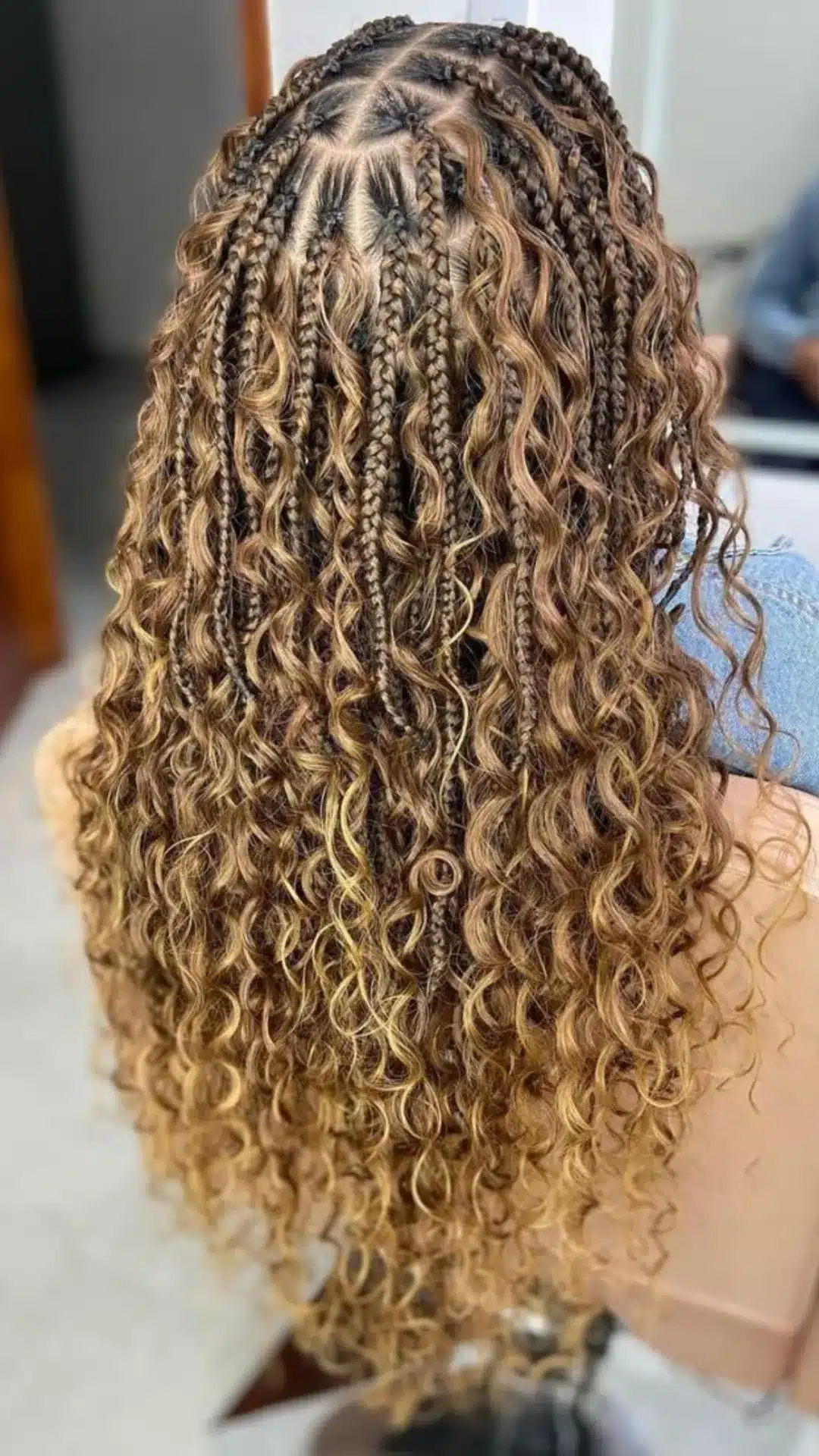 black girl with blonde boho braids featuring honey highlights loose curls and long protective braid hairstyle back view