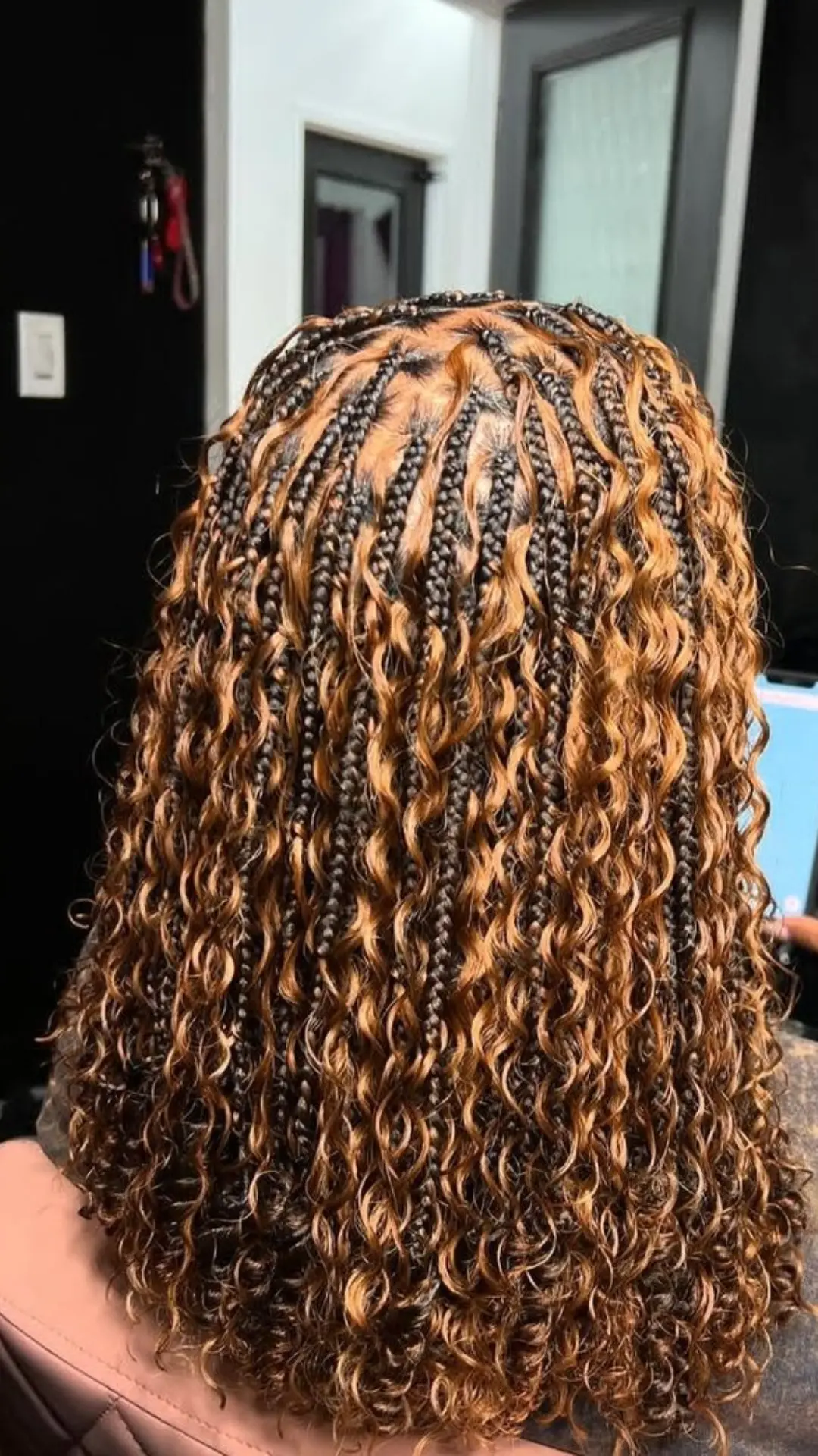 black girl with small boho braids featuring honey blonde curly strands neat parts and shoulder length braided style