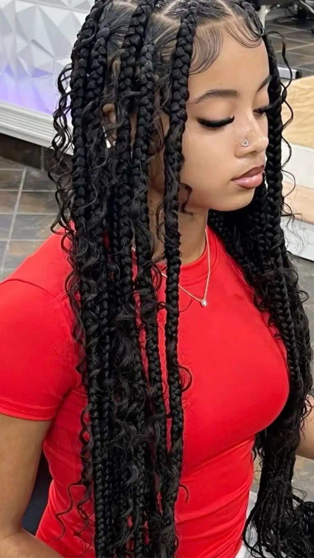 black girl with jumbo boho braids featuring loose curly strands defined parts and long protective hairstyle side view