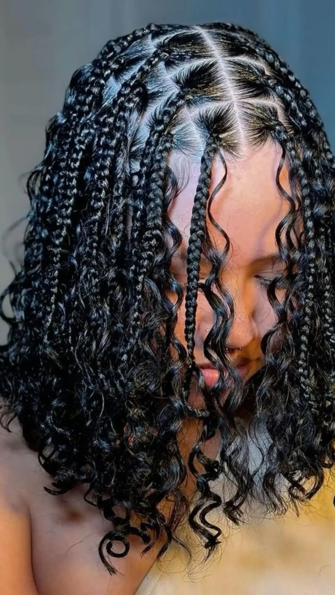 black girl with chin length bob boho braids featuring loose curls neat center part and defined protective hairstyle
