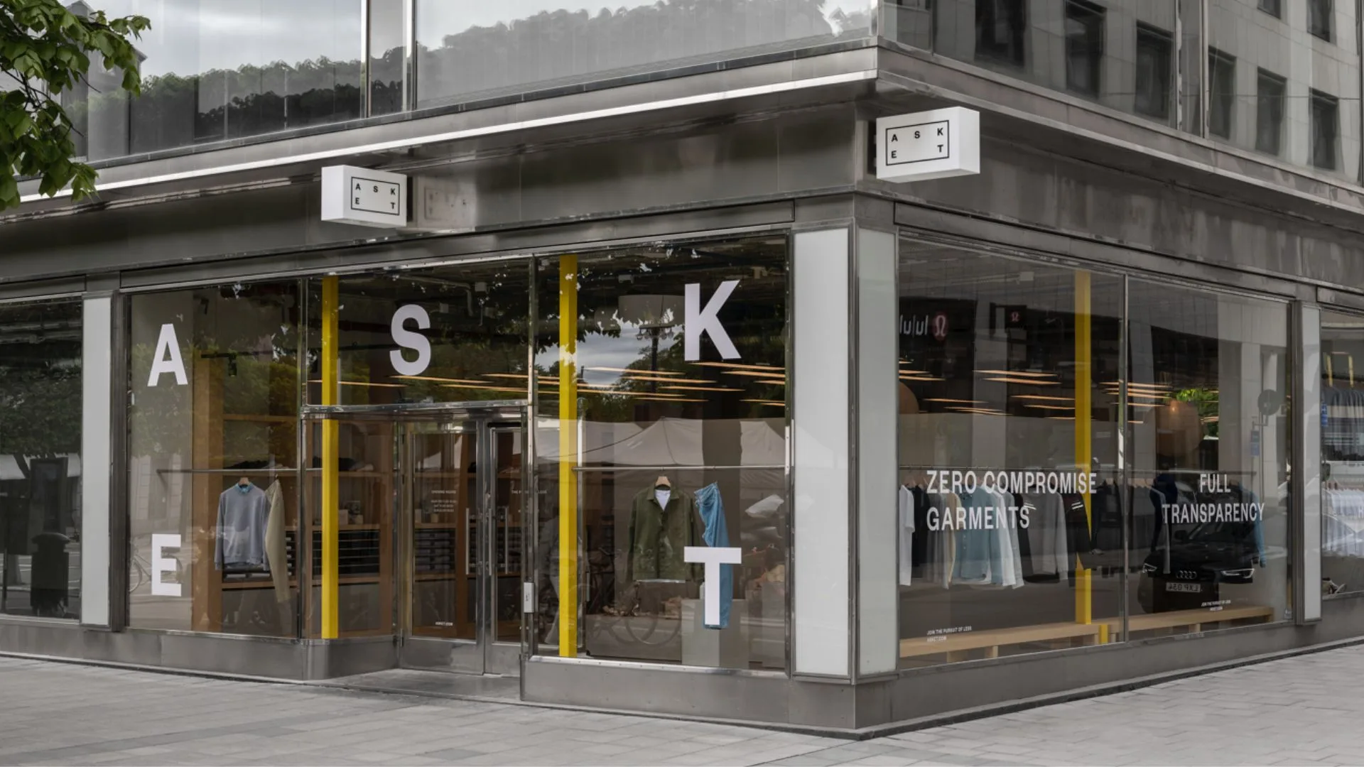 A modern clothing storefront with large glass windows featuring the brand name