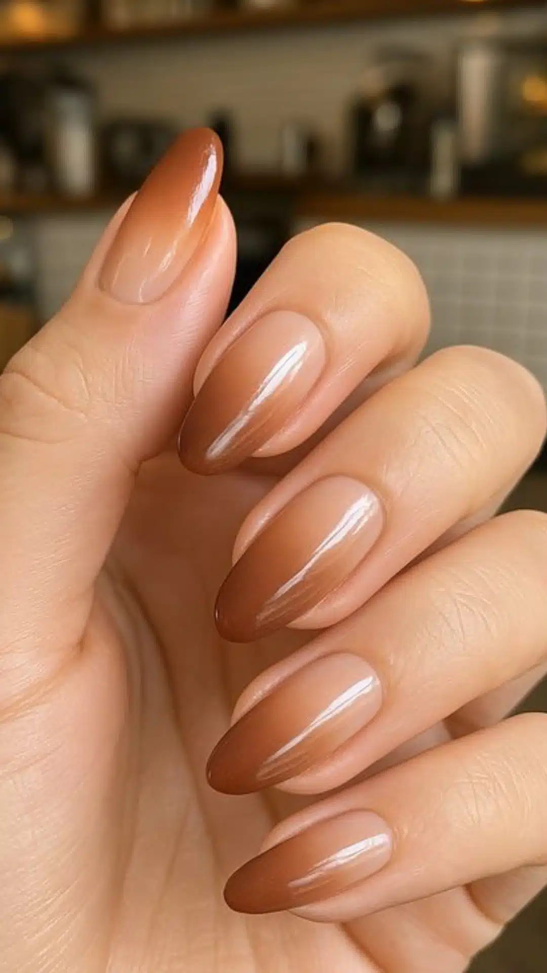 Almond nails with a caramel brown to nude ombre gradient