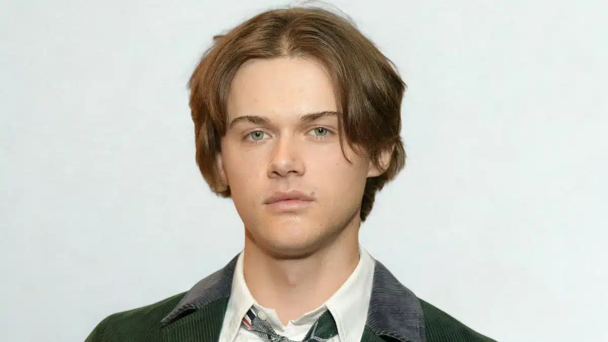 Chris Briney with brown hair, dressed in a green jacket, poses for the photo.