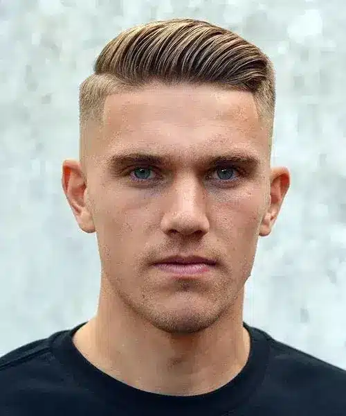 Comb over haircut with a side swept top clean fade and polished modern finish