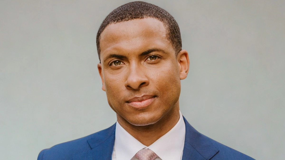 Errol Barnett wearing a suit and tie, presenting a professional appearance.