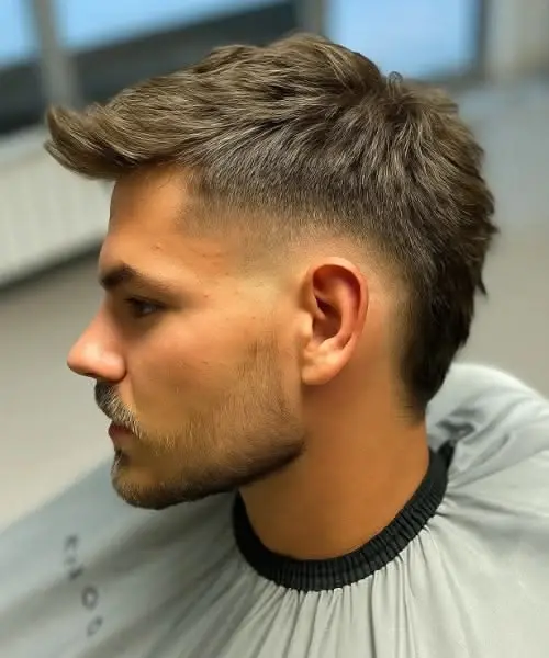 Faux hawk haircut with a textured raised center tapered fade and short sides