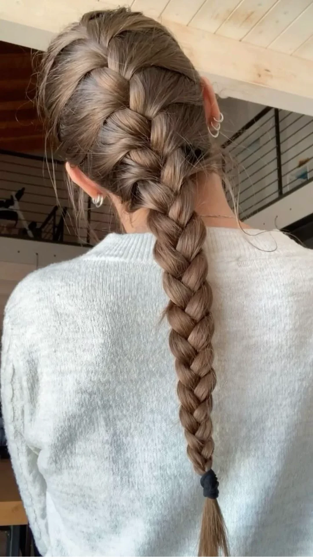 back view of a smooth brunette french braid with even woven sections creating a clean polished hairstyle for everyday wear