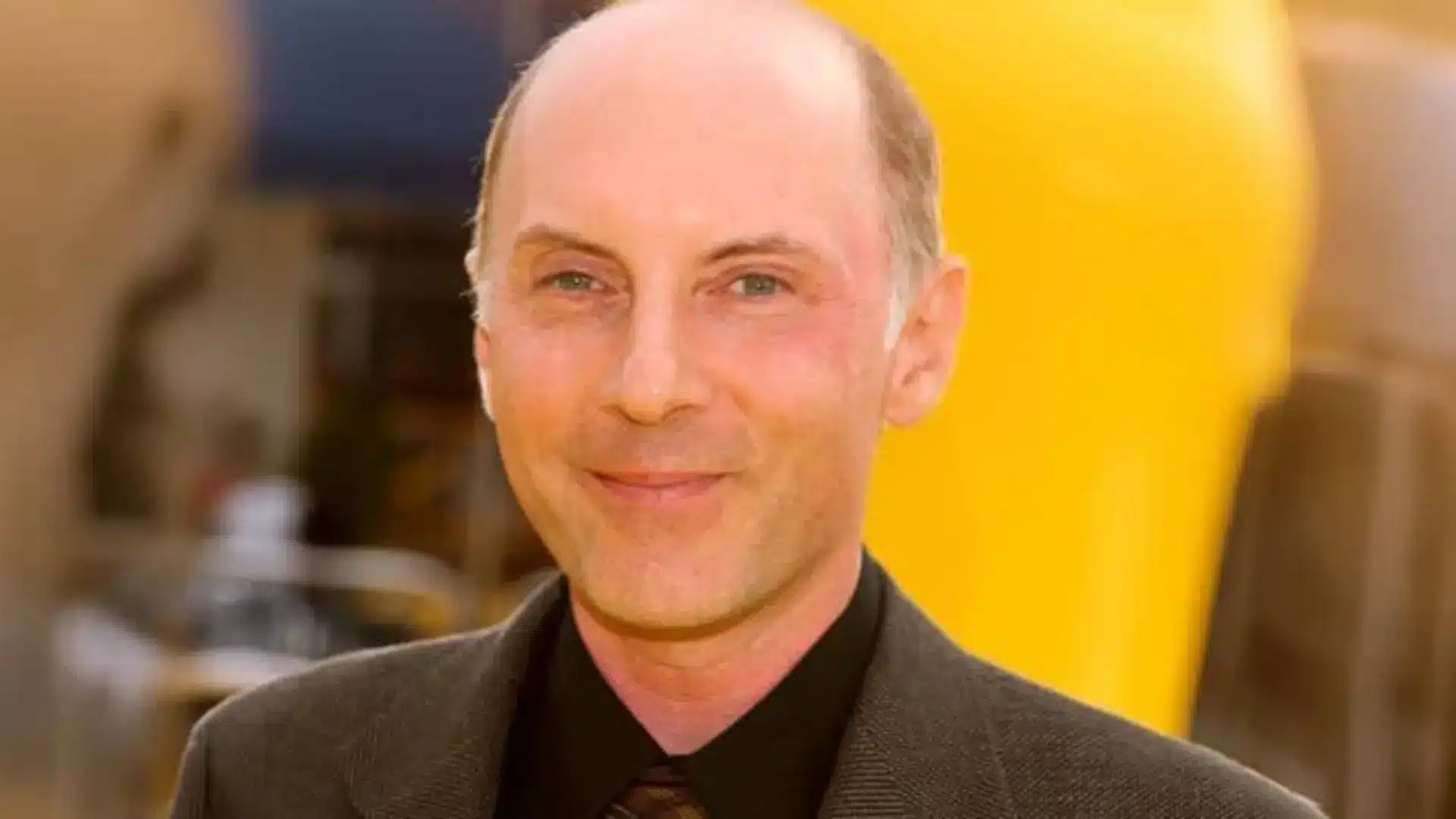Dan Castellaneta smiling outdoors in a dark jacket